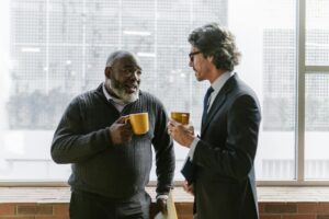 The picture of two men having a discussion over cups of tea. Showing mentorship in nonprofit leadership